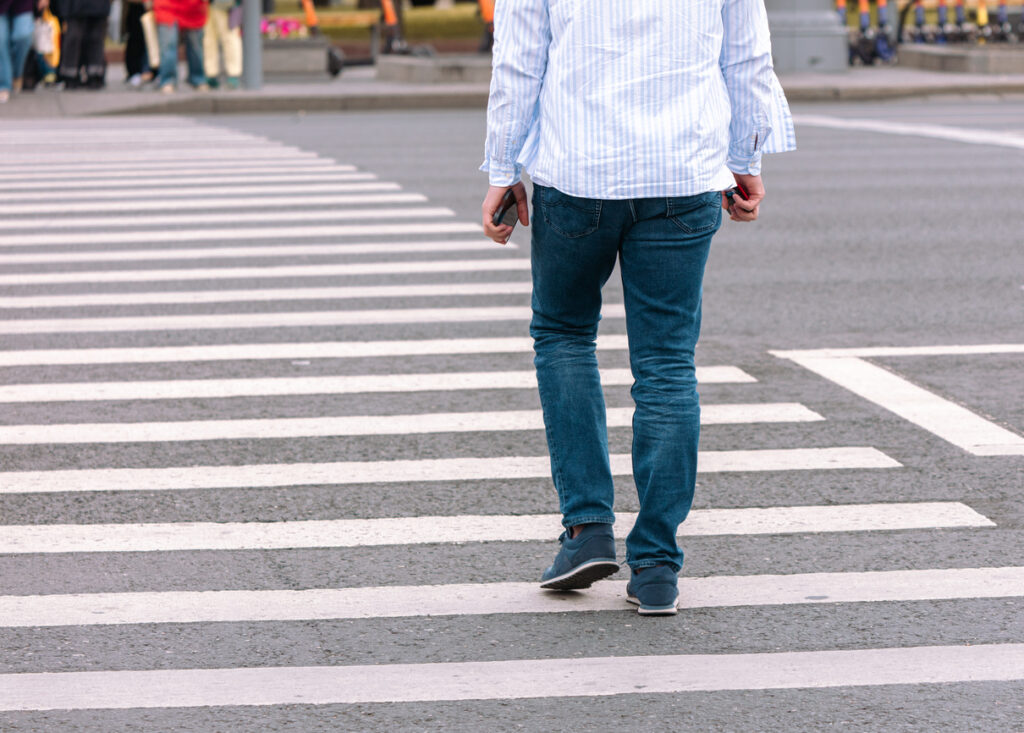 A man crosses the road on crosswalk in Long Beach